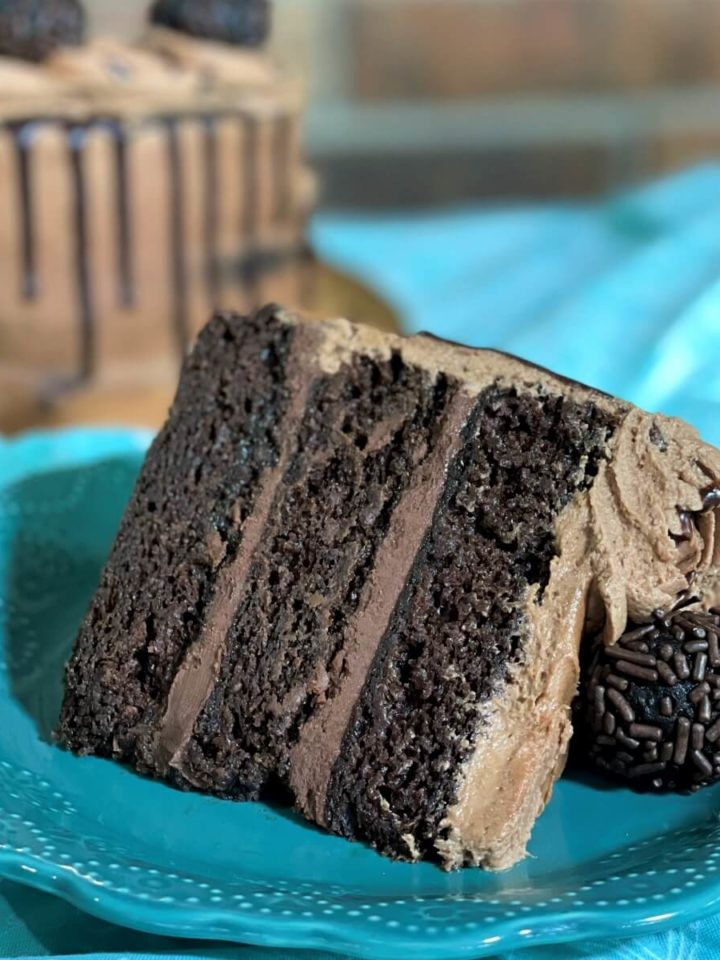 a slice of fudgy triple chocolate ganache cake