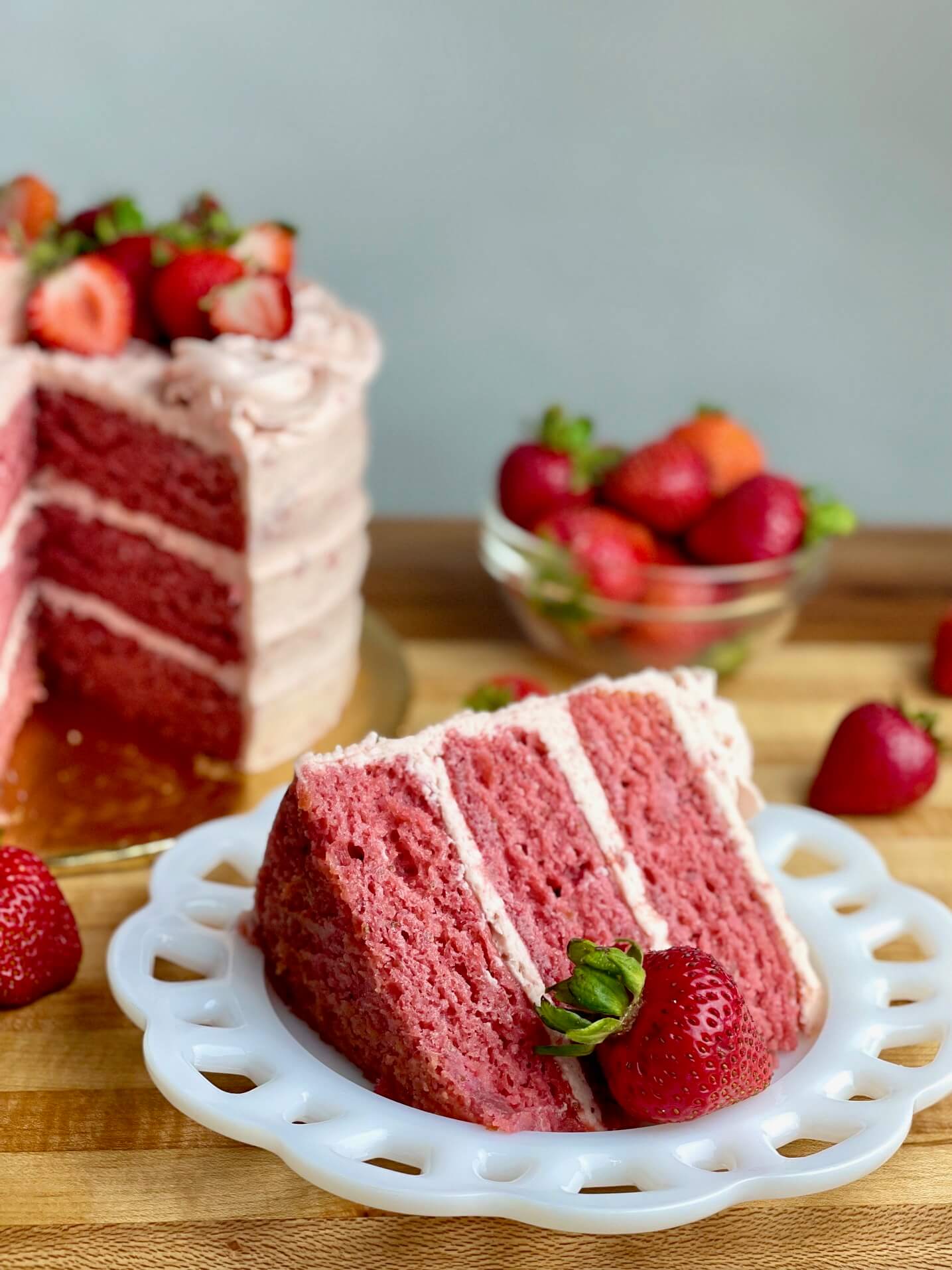 Fresh Strawberry Cake with fresh strawberry frosting and fresh berries on top.