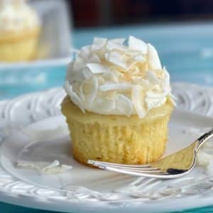 A plate with a Coconut Cream Cupcake with Whipped Cream Frosting