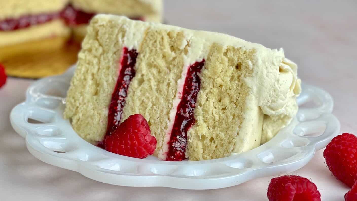 A slice of vanilla bean cake with raspberry filling.