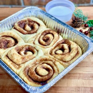 take and bake cinnamon rolls in an aluminum pan with a side of glaze