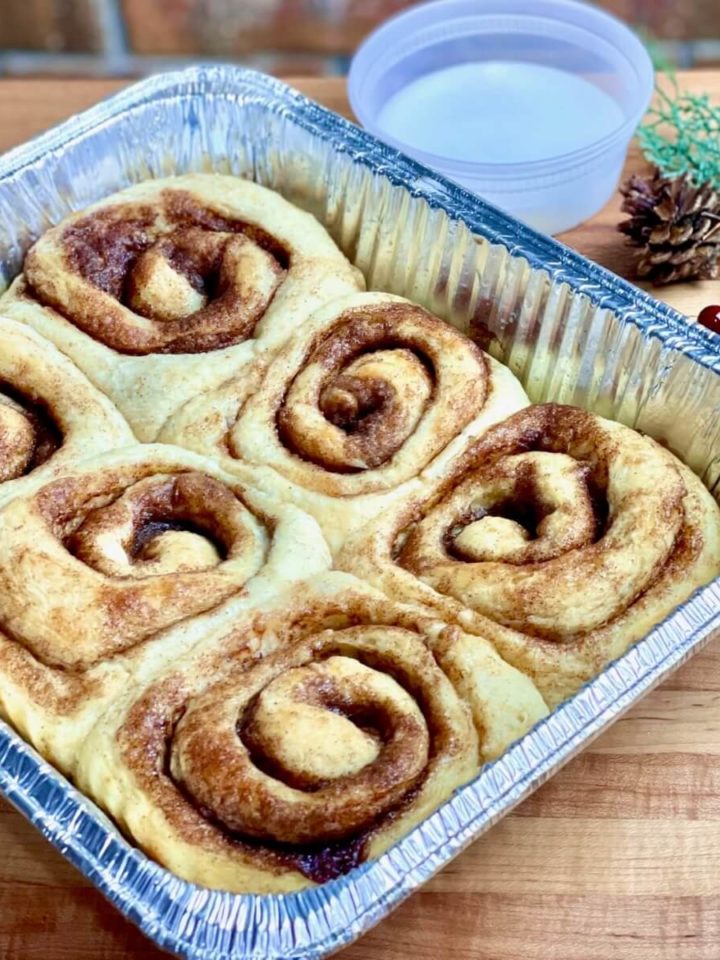 take and bake cinnamon rolls in an aluminum pan with a side of glaze