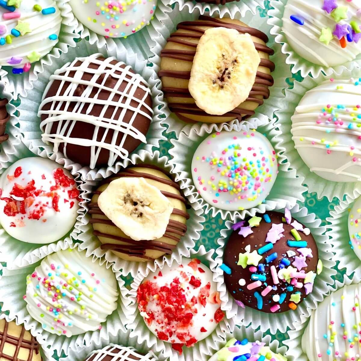 A close up of a variety of cake truffles in various flavors and decorations