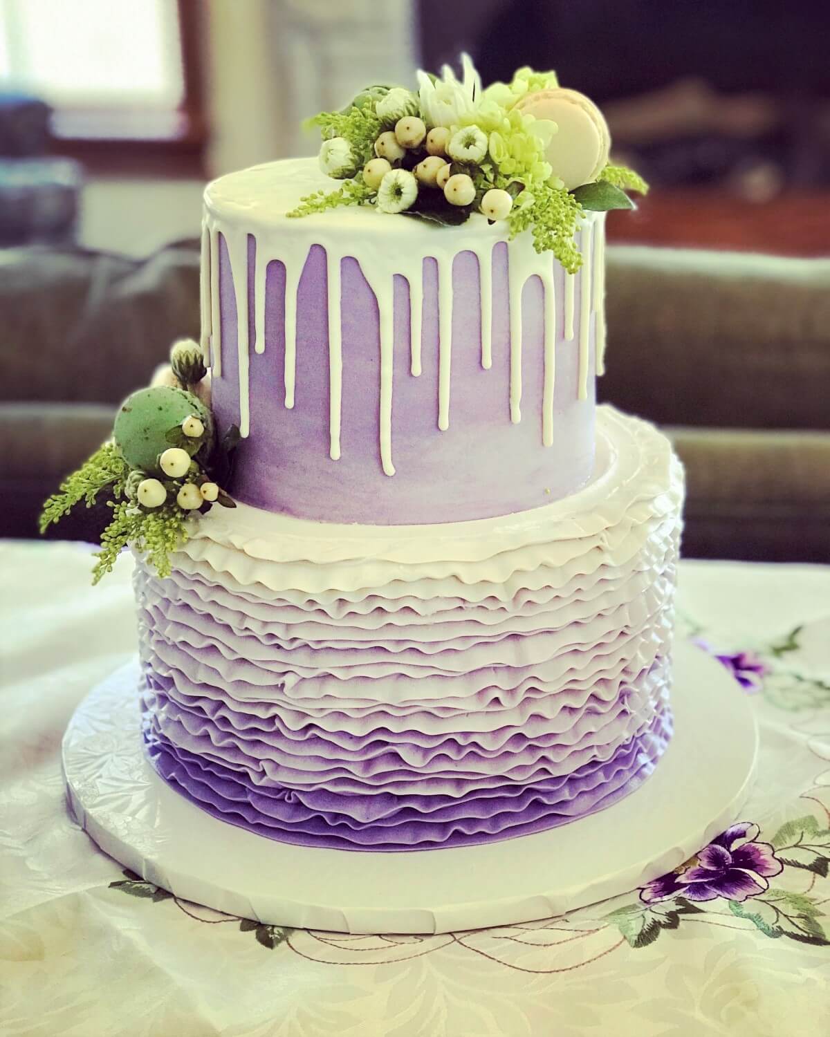 An image of a Purple Drip Cake with ruffles and flowers