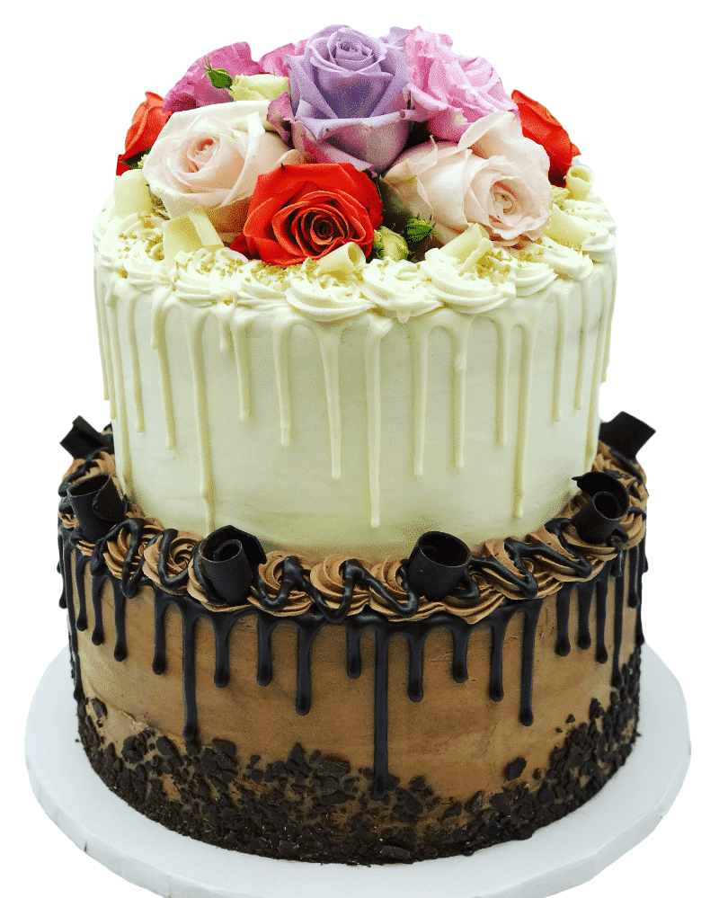 a white drip cake tiered on top of a chocolate drip cake, topped with fresh flowers