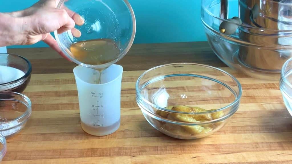 a bowl of overripe bananas, and strained banana juice being poured into a measuring cup