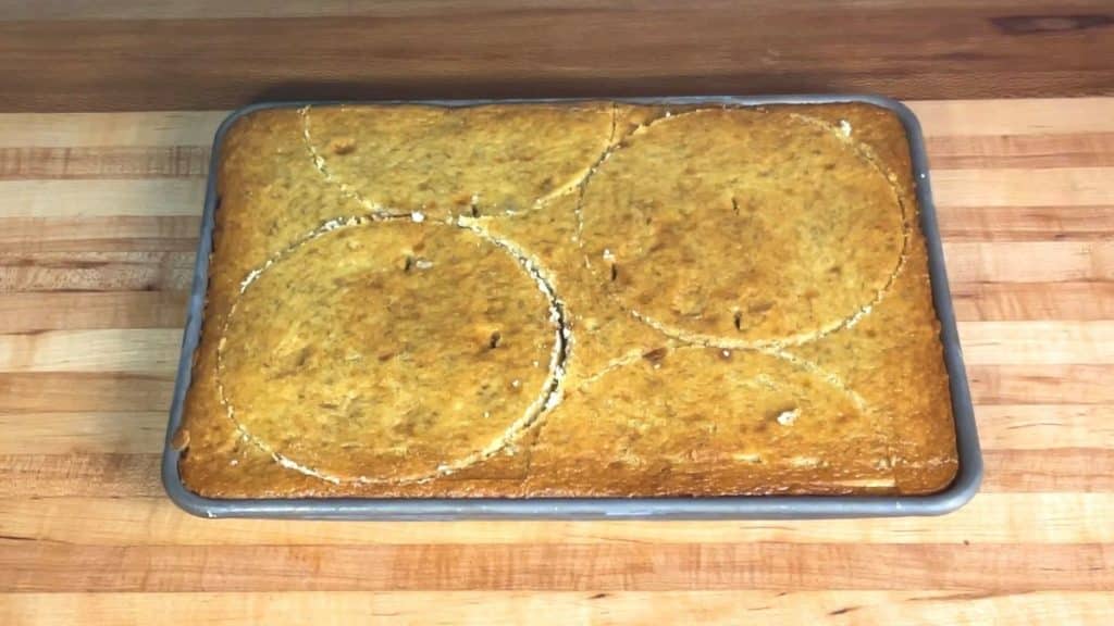 a ¼ sheet pan of baked banana cake cut out into 3 6" cake layers with cake rings