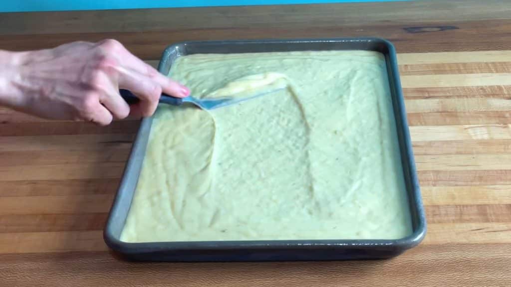 spreading the banana cake into the sheet pan