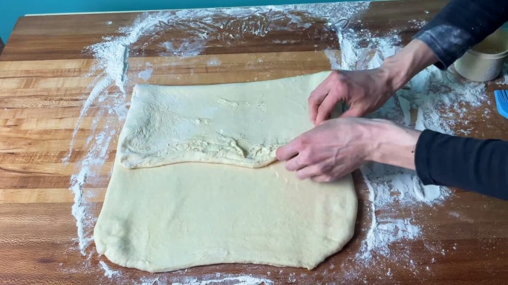 A rectangle of dough being folded into thirds.