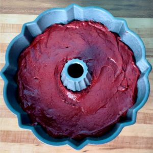 A bundt pan filled with red velvet cake batter