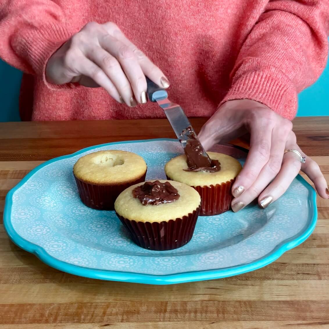 vanilla cupcakes being filled with nutella filling