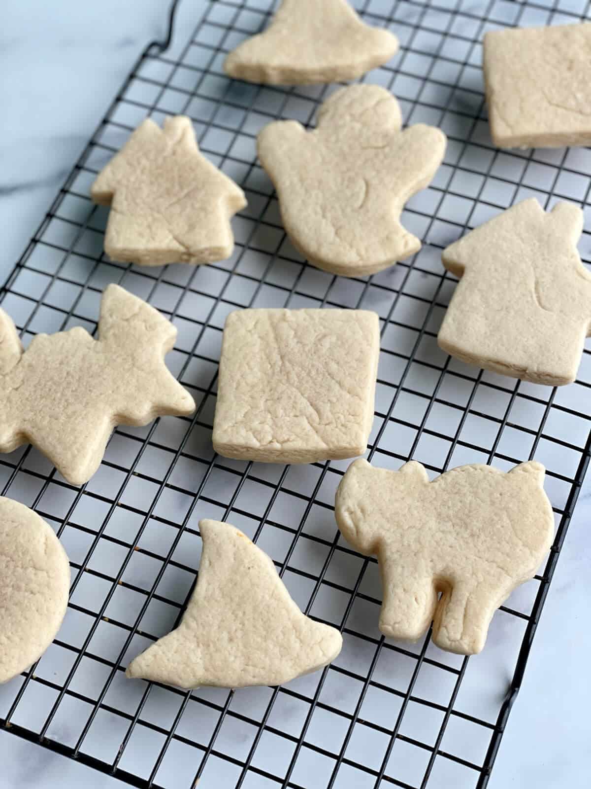 A cooling rack with unfrosted soft sugar cookies, rolled out thick