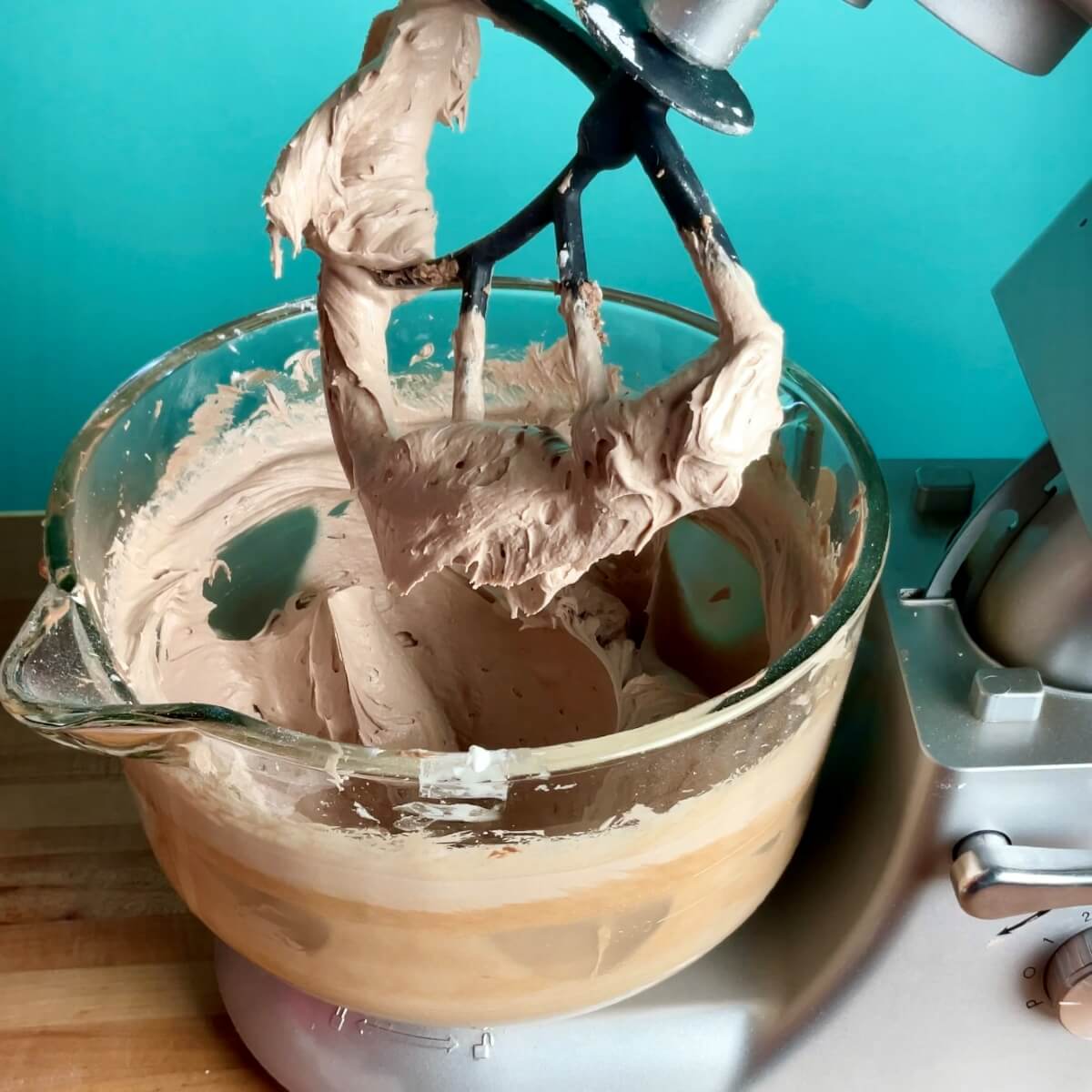 a stand mixer with the mixer bowl full of fluffy nutella buttercream.