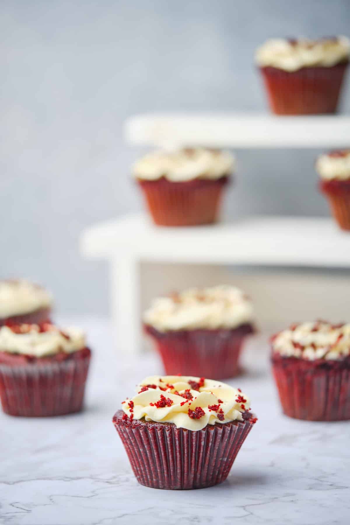 Several Red velvet cupcakes with cream cheese buttercream frosting.