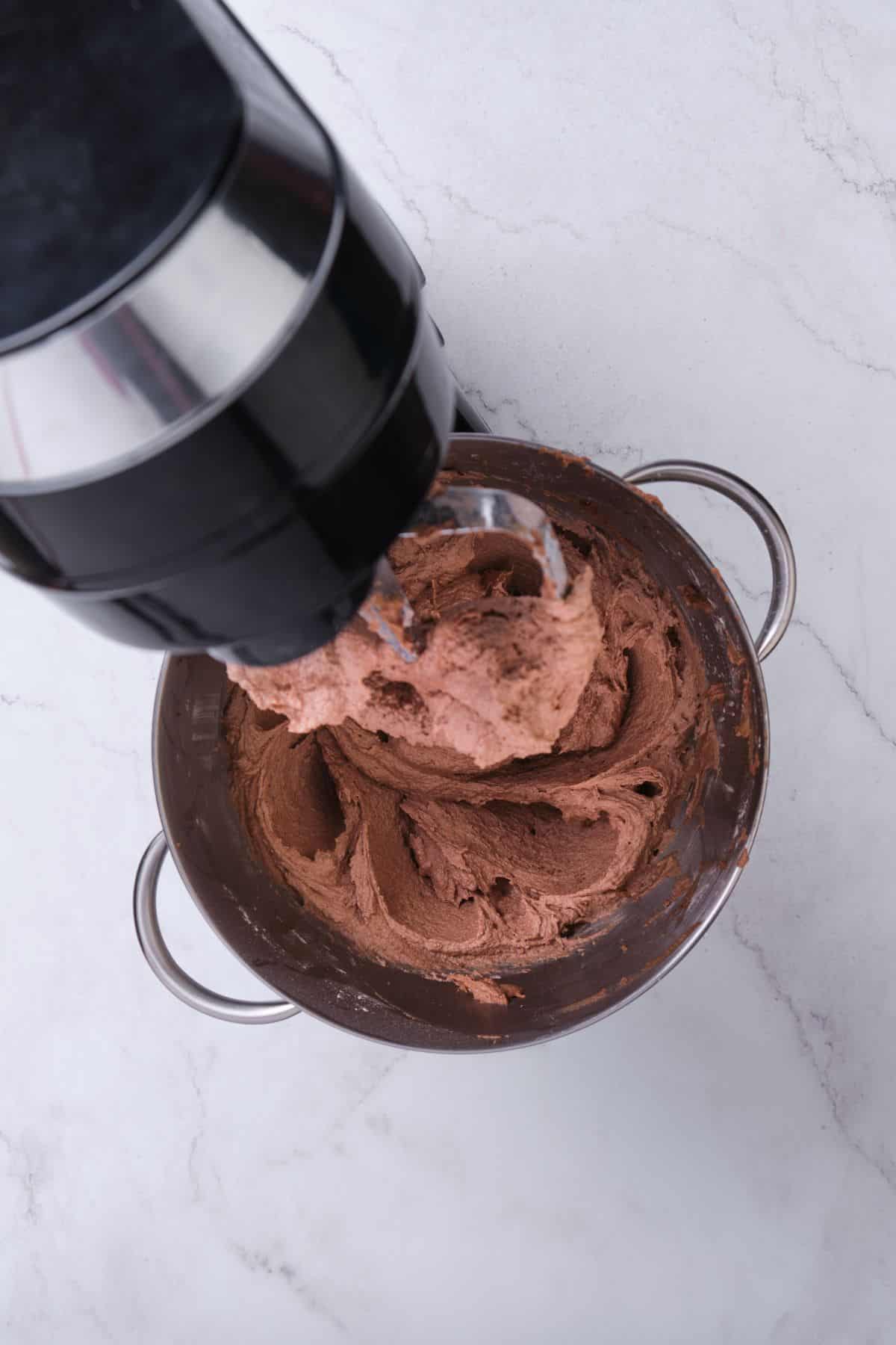 Chocolate buttercream in a stand mixer.