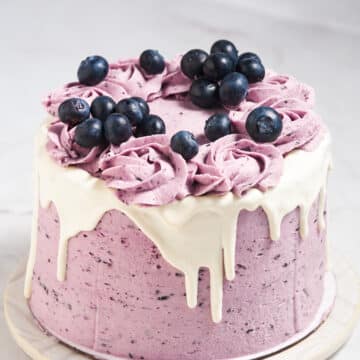 A blueberry layer cake topped with fresh blueberries.