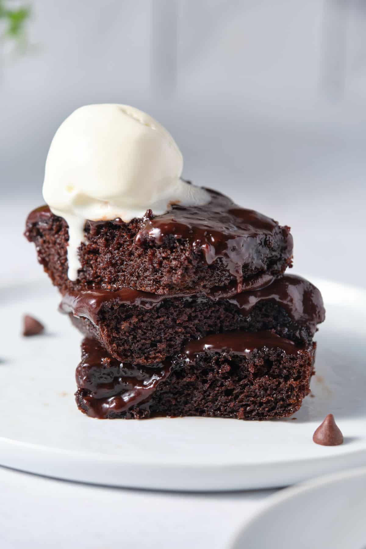 Moist chocolate fudge cake with melting vanilla ice cream on top.