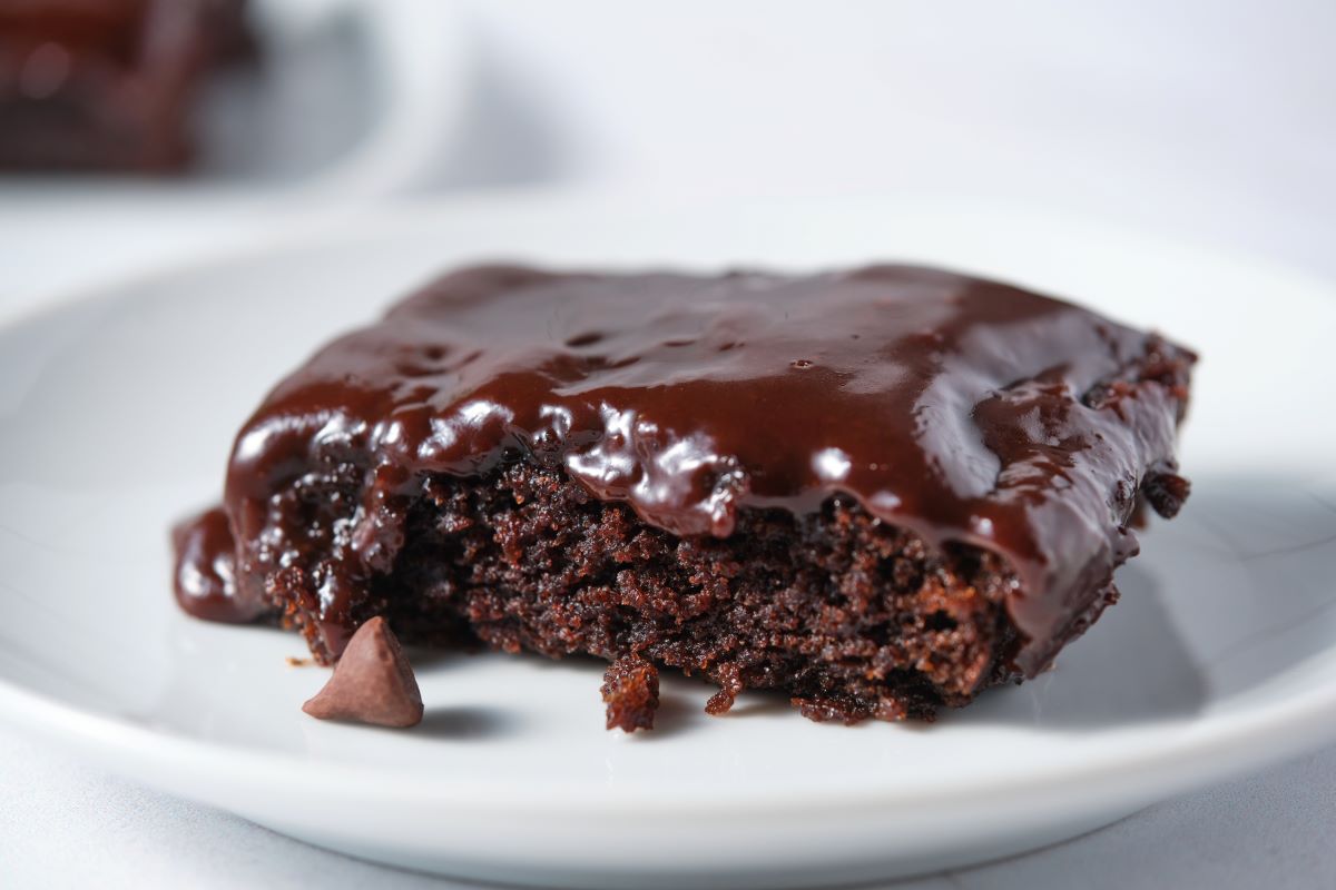 A close up of moist chocolate fudge cake with fudge icing.