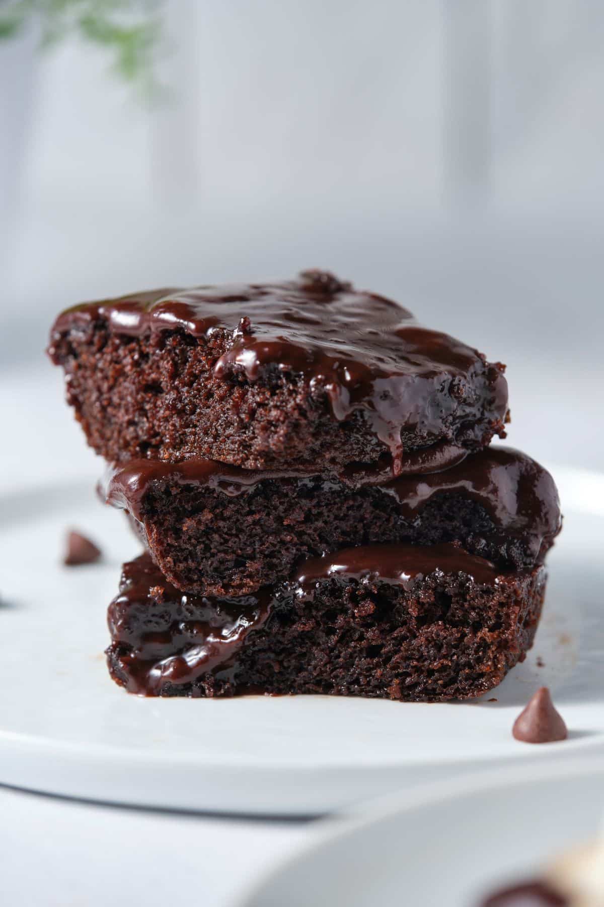 Stacked moist and fudgy chocolate fudgy cake on a plate.