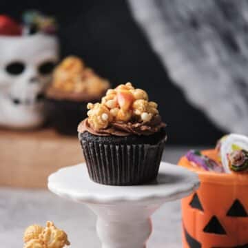 Chocolate caramel filled cupcakes with Halloween decorations around.