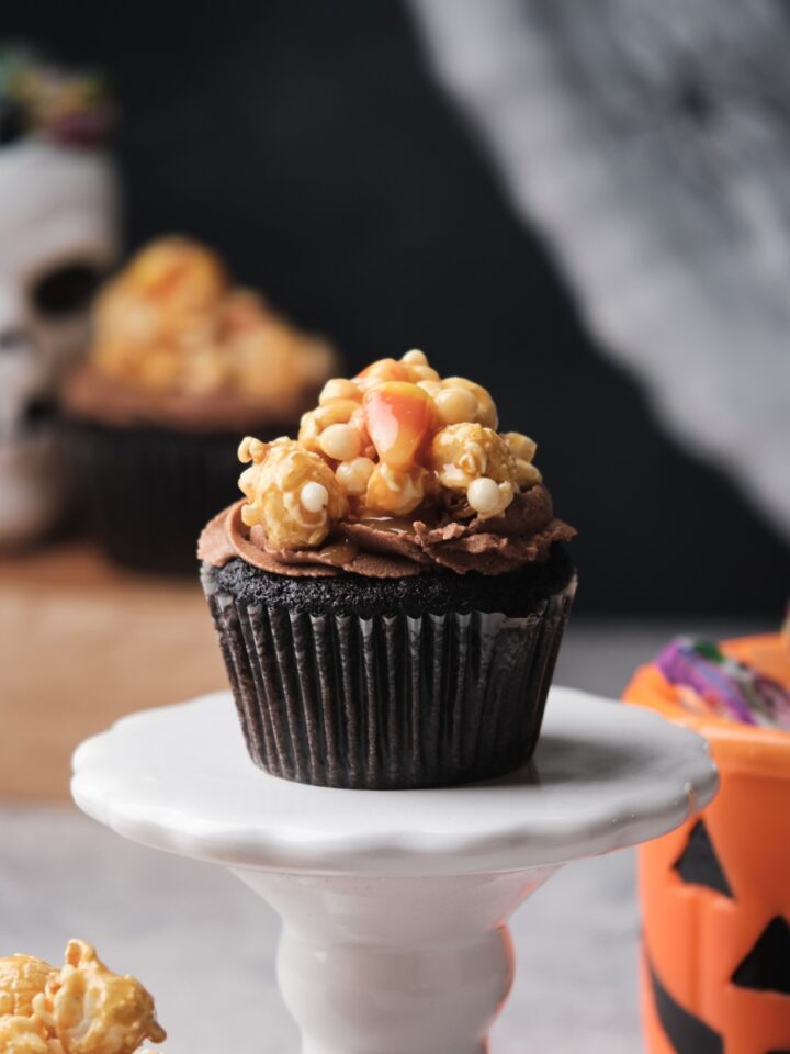 Chocolate caramel filled cupcakes with Halloween decorations around.