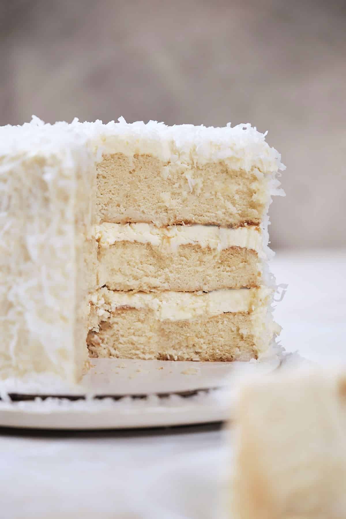 A three layer coconut cake cut open.