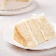 A moist slice of sour cream coconut poke cake on a plate.