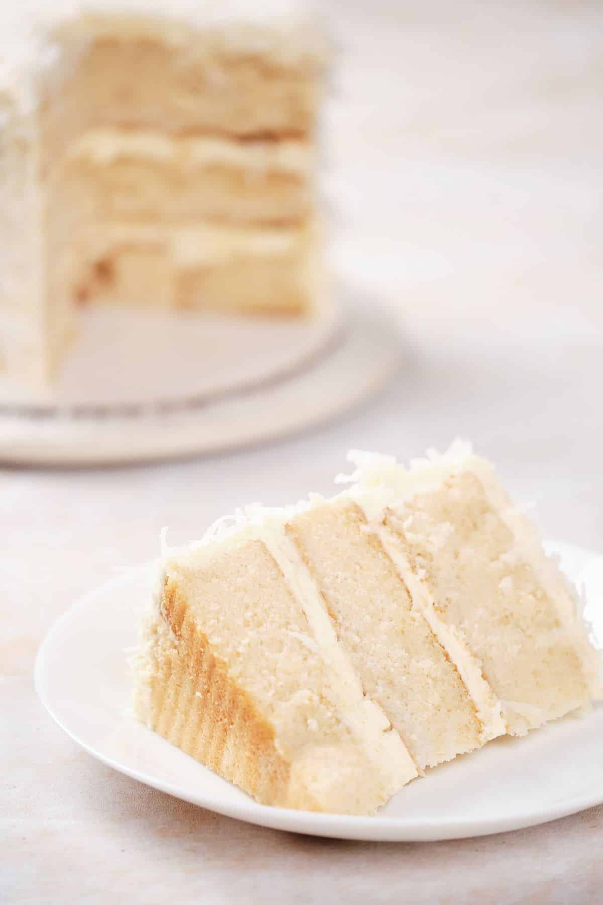 A moist slice of coconut cake on a plate.