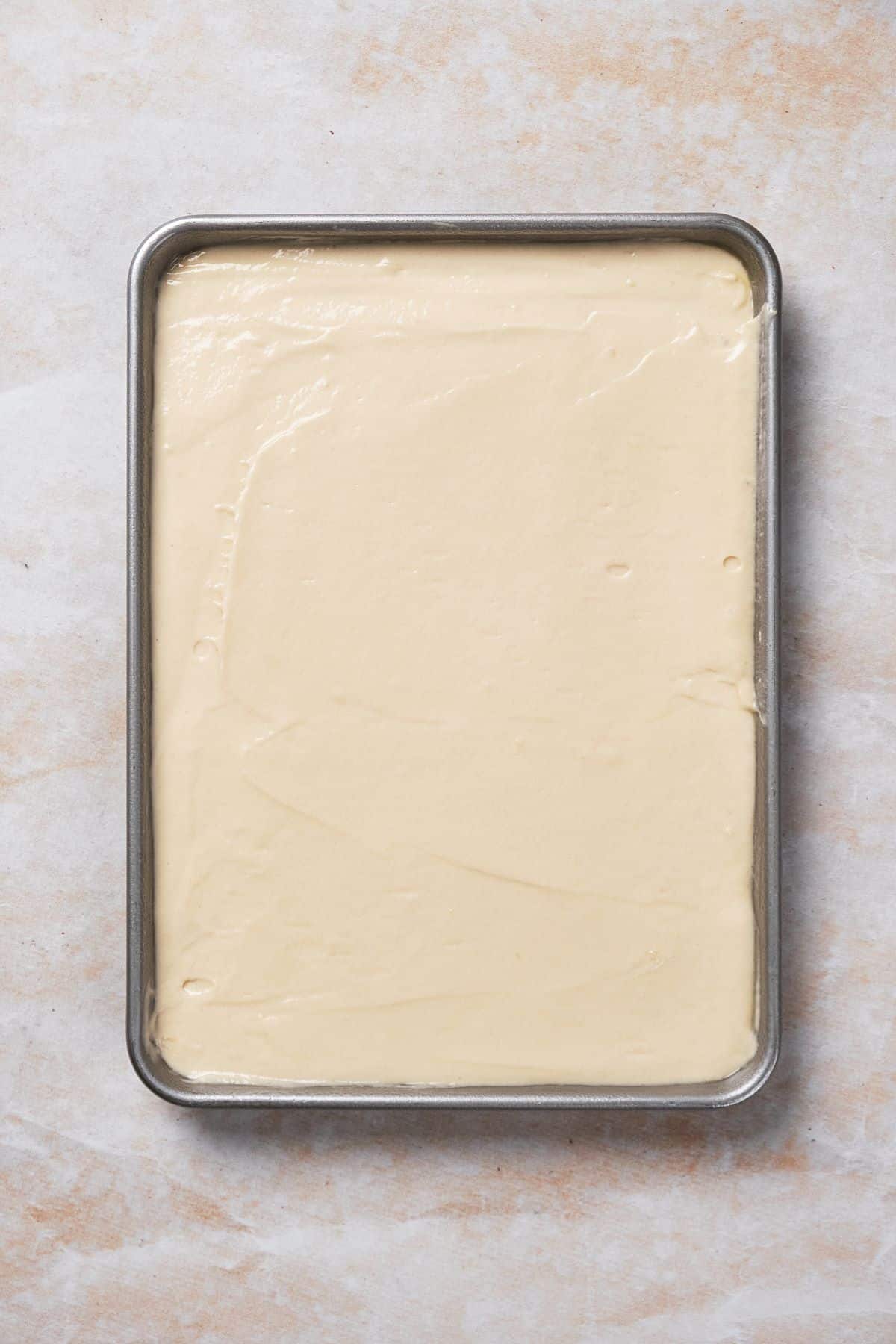 Sour cream coconut cake batter in a cake pan.