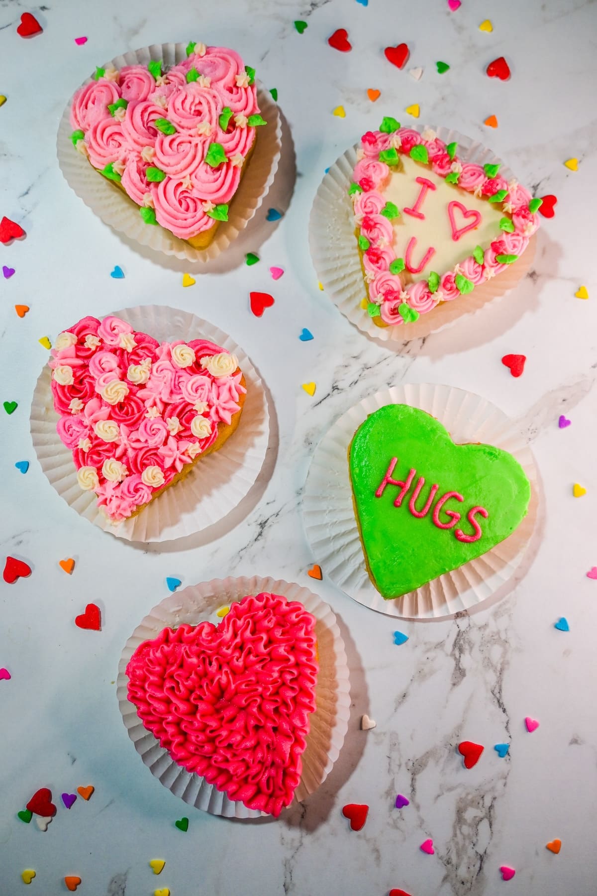 Mini heart cakes decorated with colorful buttercream designs.