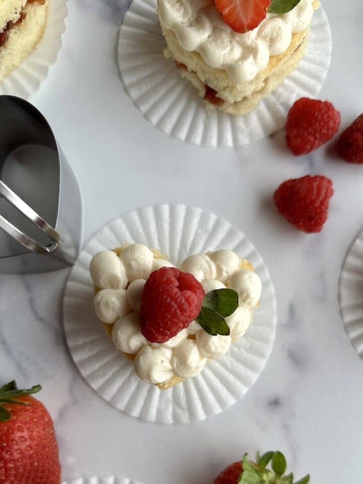 Mini heart cakes topped with fresh strawberries and raspberries.