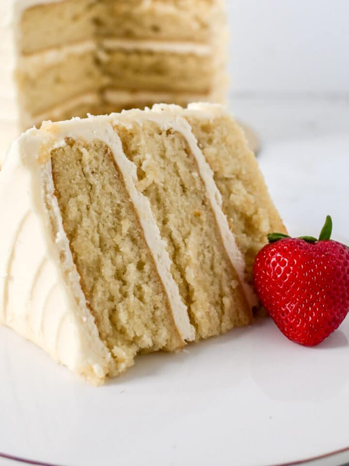 closeup shot of vanilla cake made using the reverse creaming method with a fresh strawberry.