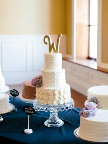 three layered wedding cake made with vanilla almond cake on a cake stand in front of a window.