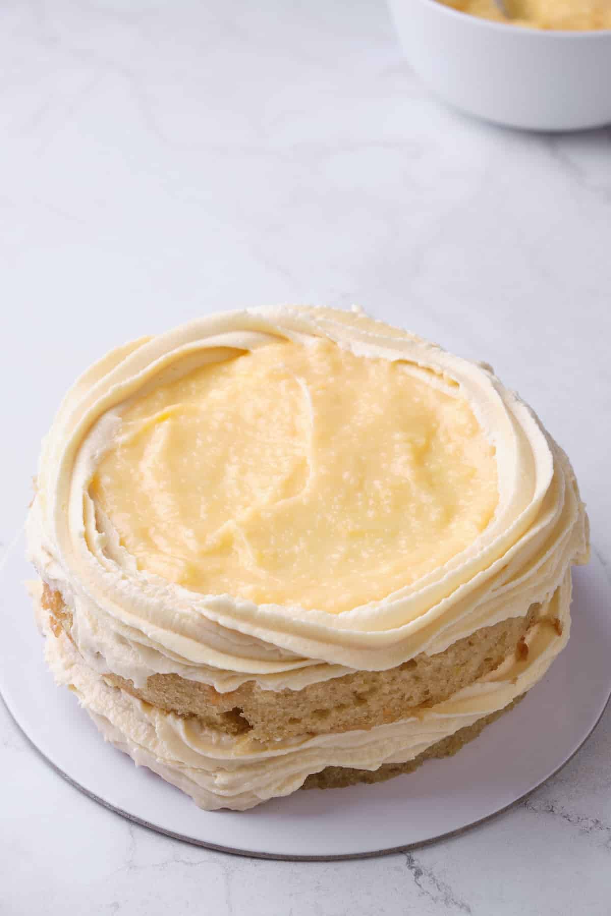 filling a cake with lemon curd filling.