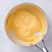 close up view of lemon curd in a pan ready for filling bakery style cakes.