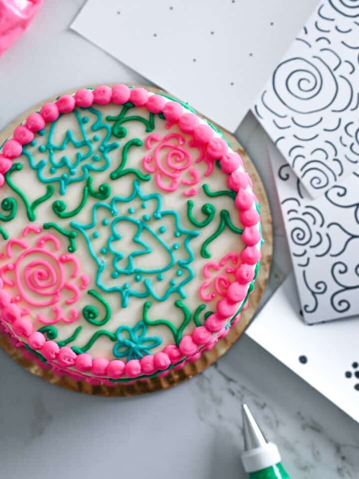 image of a decorated cake next to stencils to practice cake decorating.