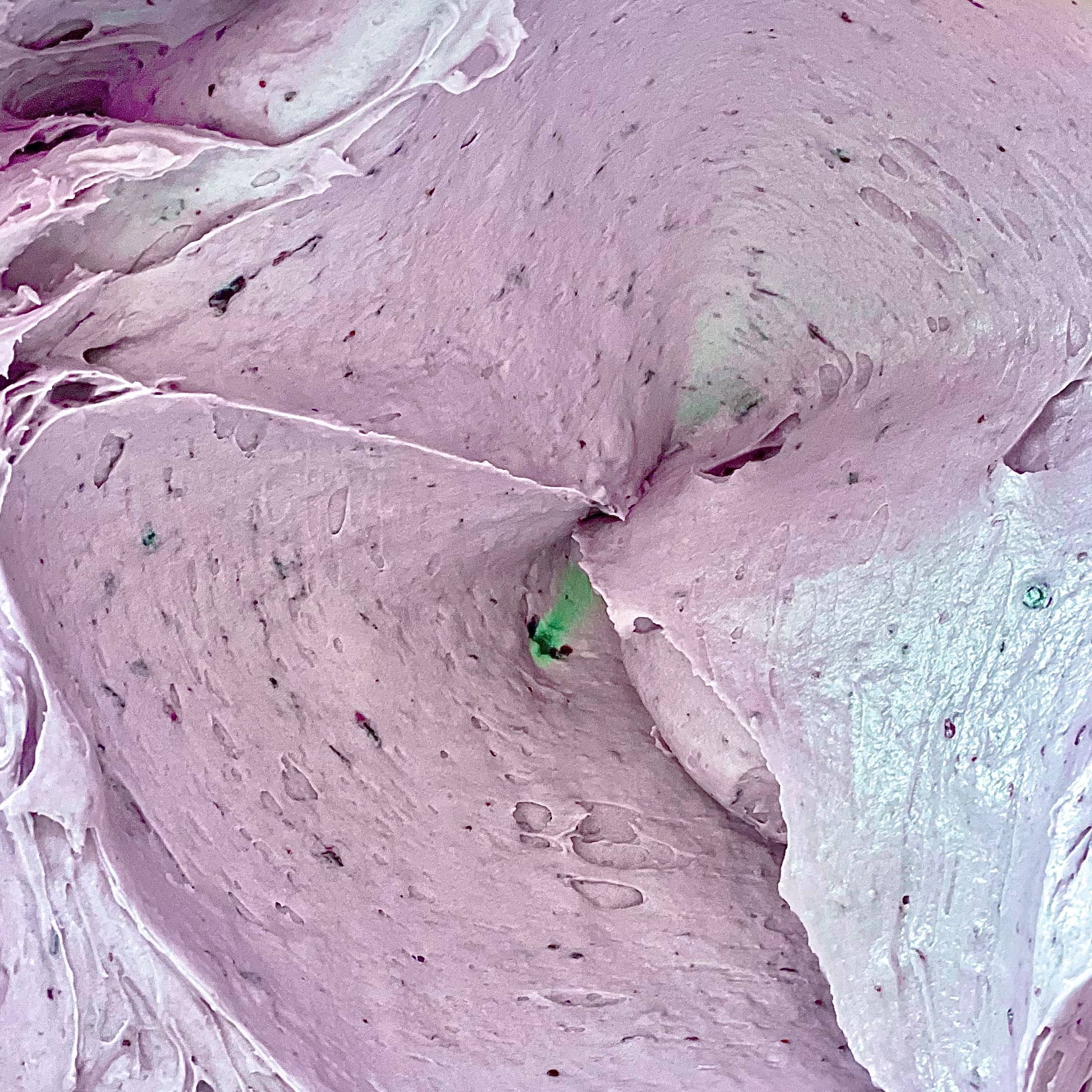 mixing bowl with creamy fresh blueberry buttercream made with blueberry puree and blueberry emulsion.