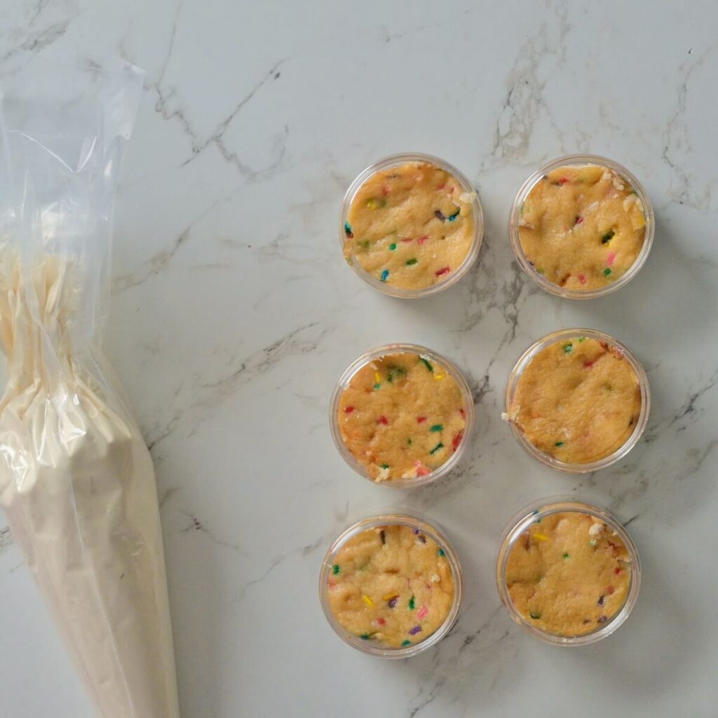 plastic jars with a single layer of funfetti cake in each one.