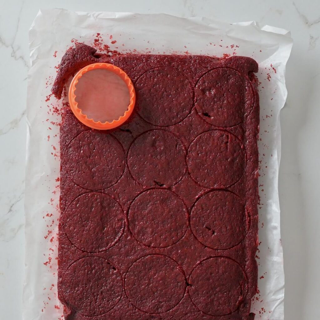 1x batch of red velvet cake cut into rounds with a cake cutter.