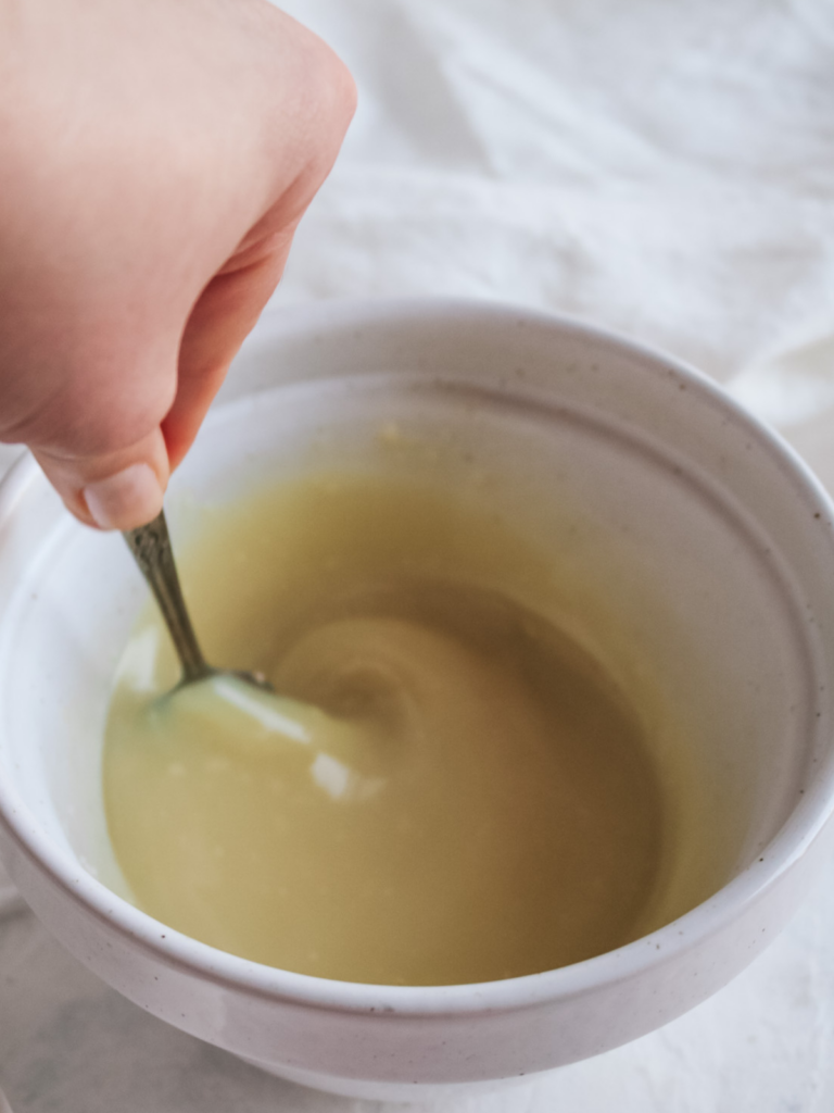 whisking melted white chocolate chips and cream together to make white chocolate ganache.