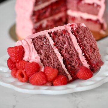 A slice of raspberry cake on a plate.