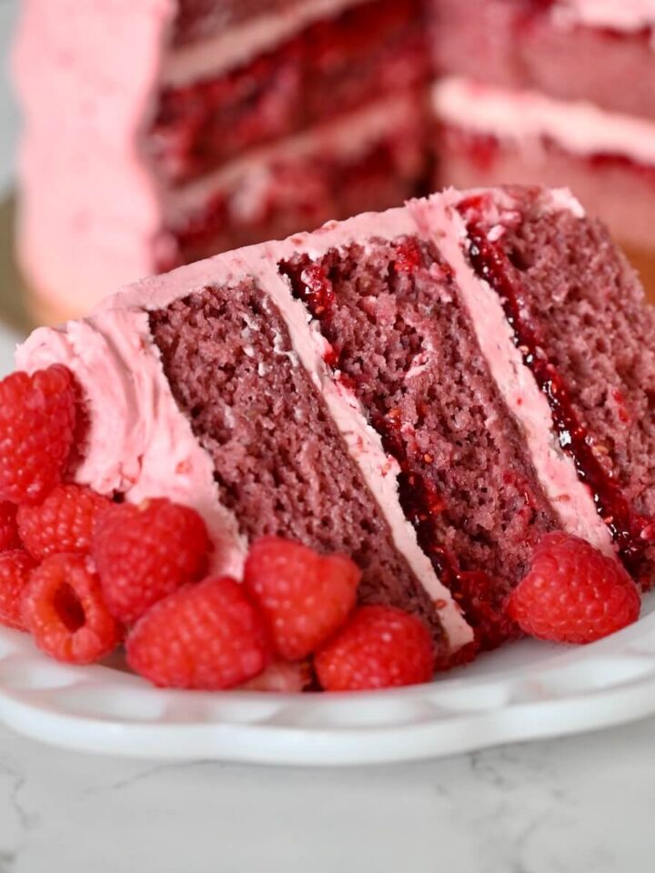 A slice of raspberry cake on a plate.