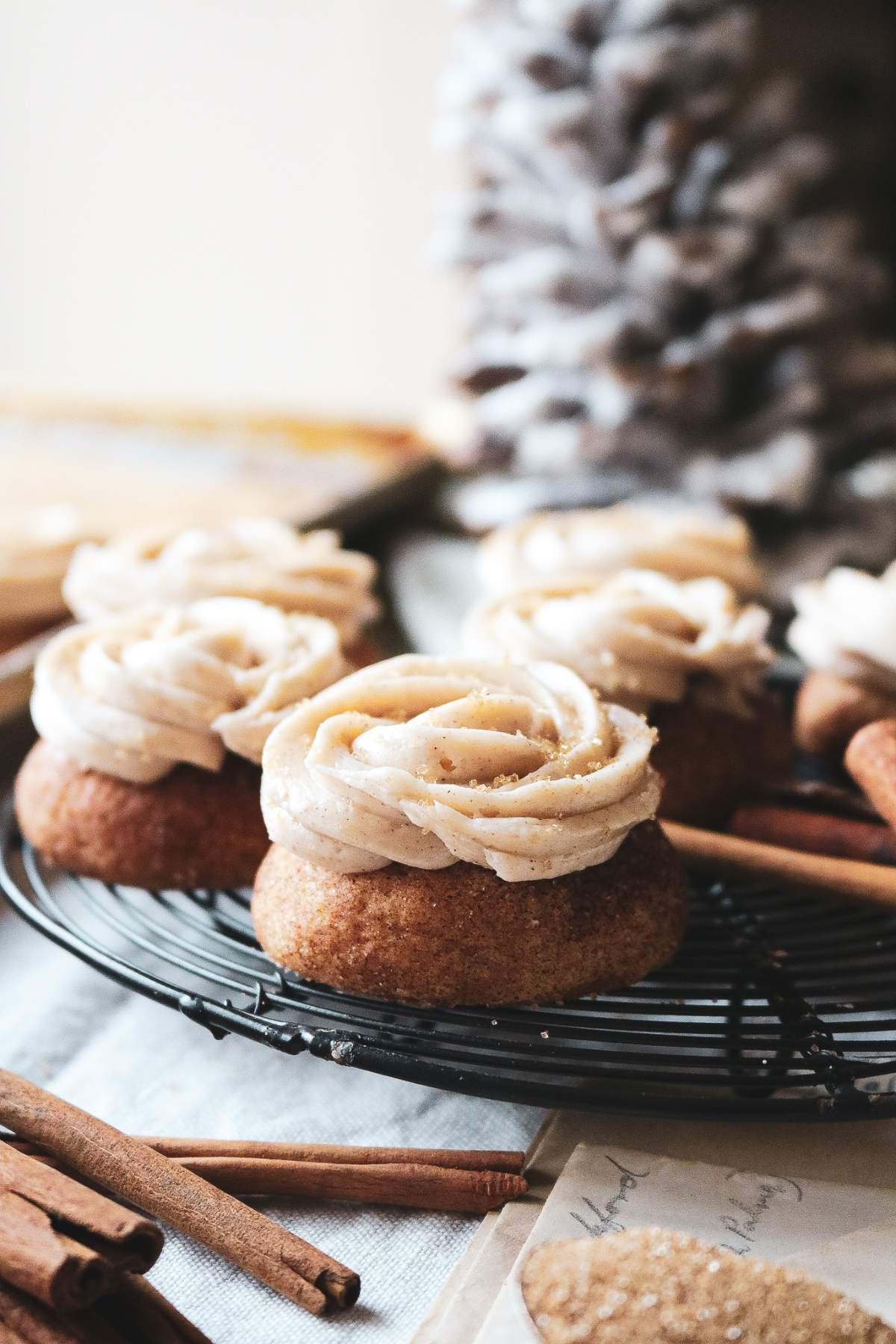 close up view of snickerdoodle cookies with cinnamon buttercream on a wire rack.
