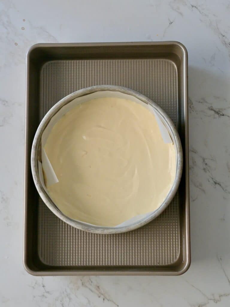 A cheesecake pan set inside a larger baking pan for a water bath, ready to go into the oven.