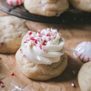 close up view of a peppermint sugar cookie topped with vanilla frosting and crushed peppermint candies.