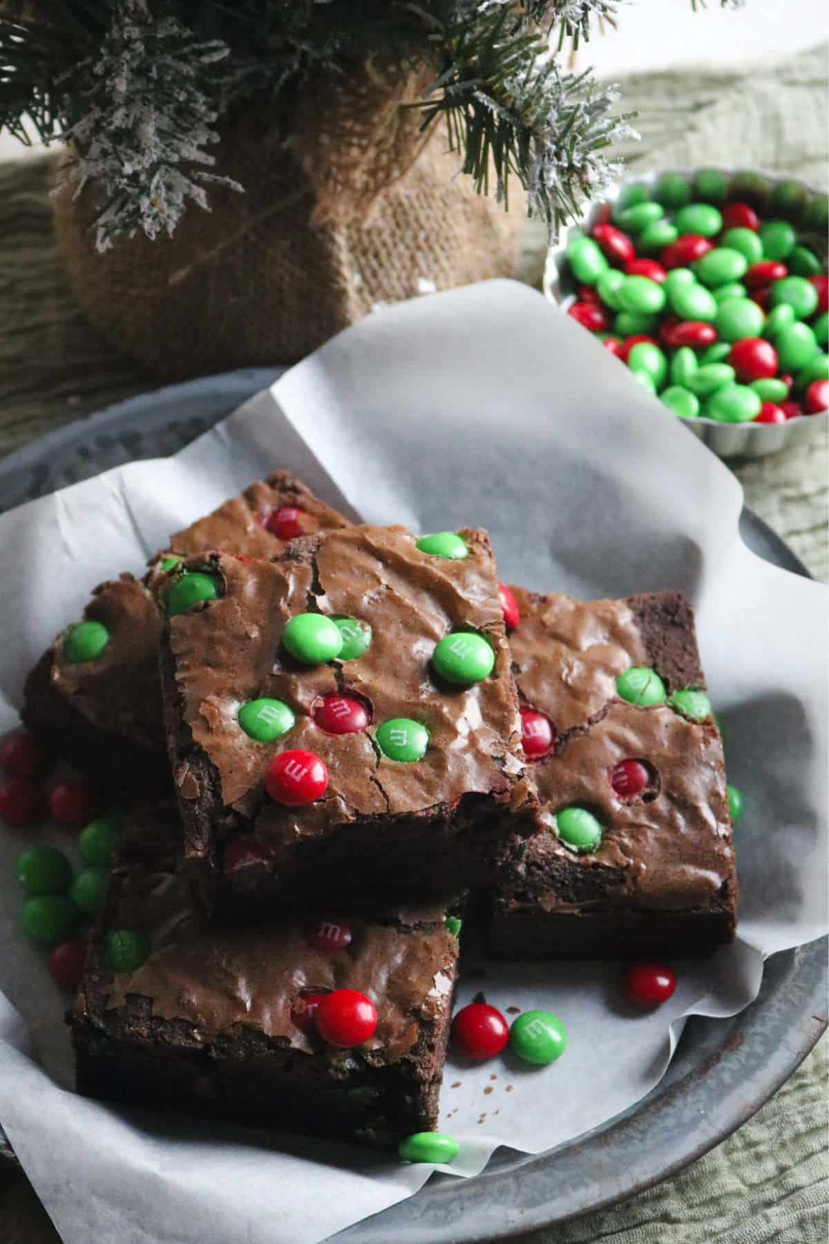 antique pie plate with christmas themed M&M brownies with red and green M&M candies.