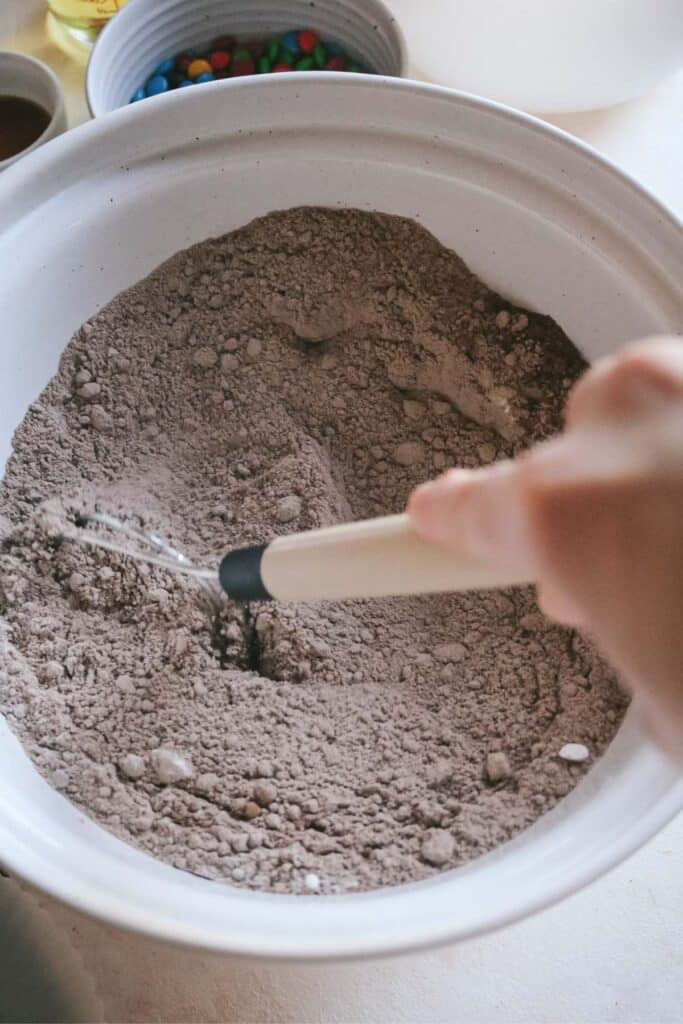 whisking brownie mixes, instant clearjel, and dry ingredients in a large mixing bowl.