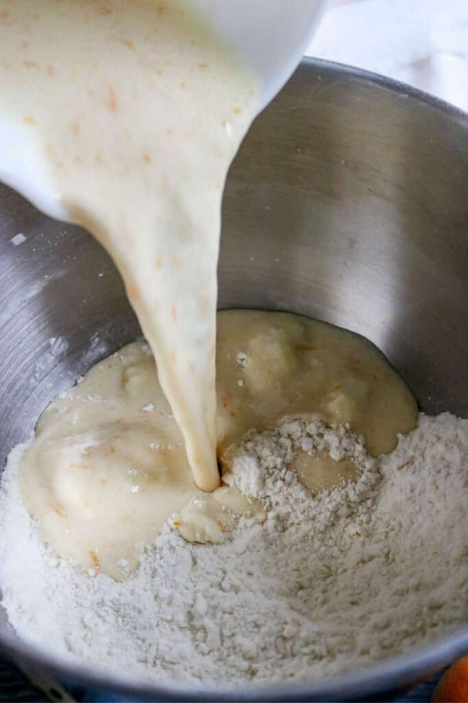adding wet ingredients to dry ingredients for orange cupcakes.