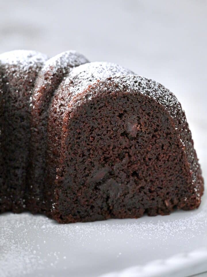 Cross section of a chocolate bundt cake showing ultra-moist chocolate crumb and pockets of chocolate chips.