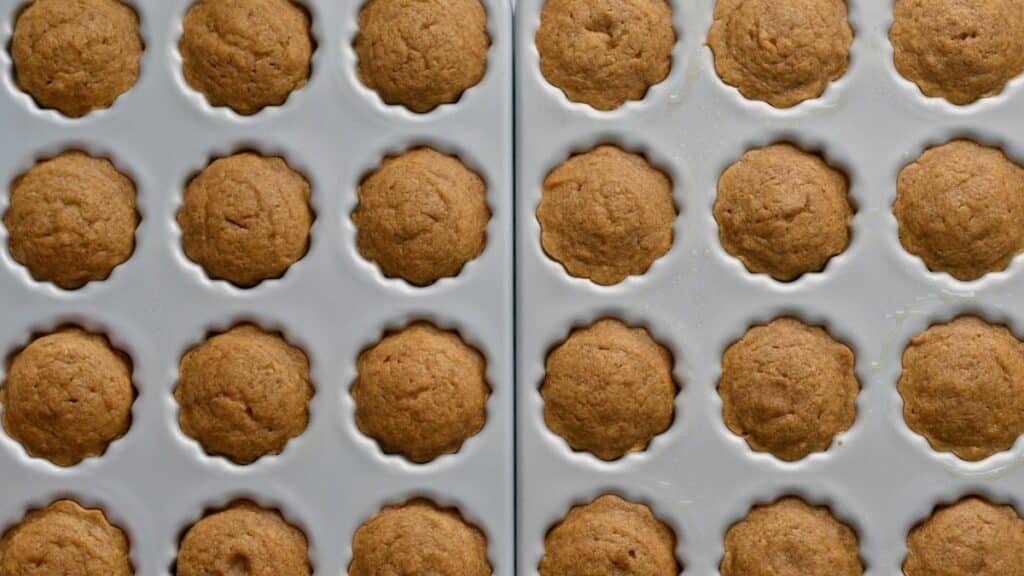 Golden baked pumpkin mini bundt cakes in two fluted mini bundt pans, fresh from the oven.